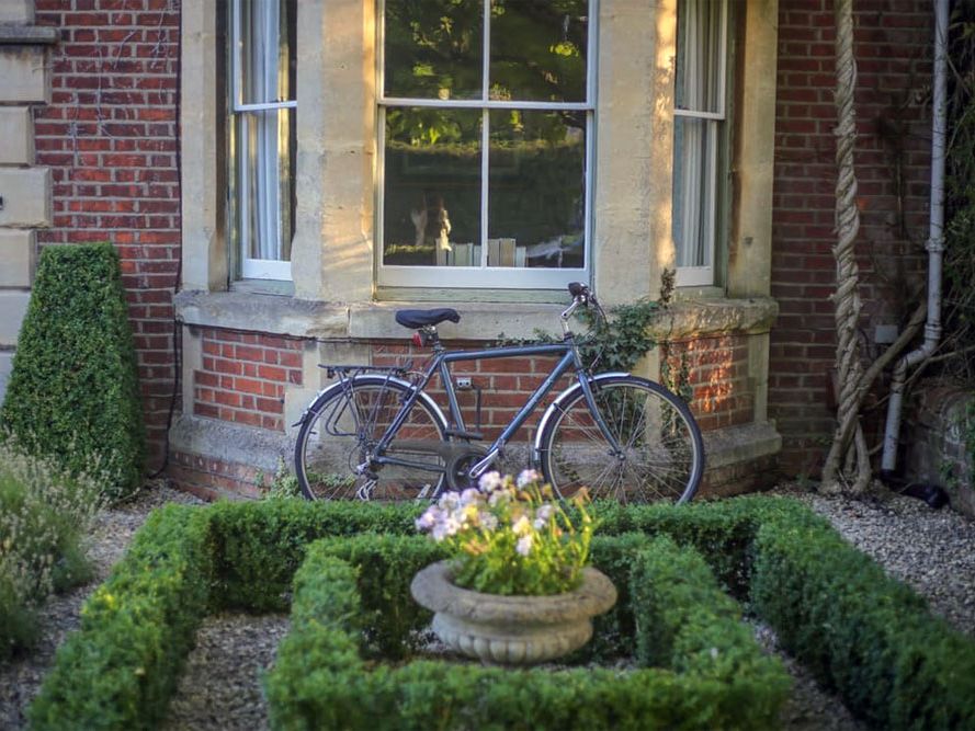 Formgeschnittener Buchsgarten mit dekorativem Fahrrad